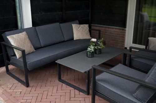 a blue couch and a table on a patio at Holiday home de Stamhoeve in Biezenmortel