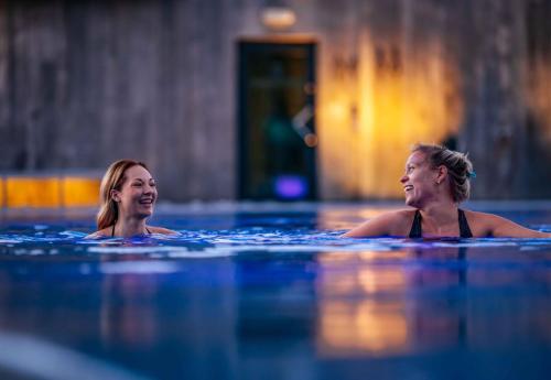 two women in the water in a swimming pool at The Well in Kolbotn