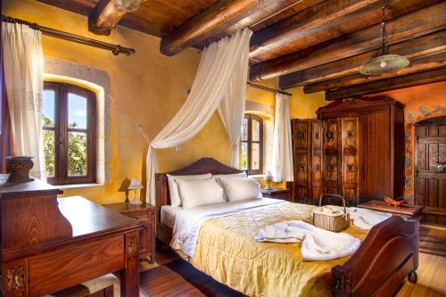 a bedroom with a bed and a desk and a piano at Samonas - Orange villa Diktamos in Khiliomoudhoú
