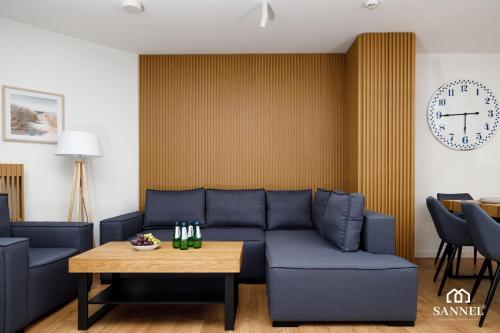 a living room with a blue couch and a table at Apartament Premium Marin - Pinea Apartments Pobierowo in Pobierowo
