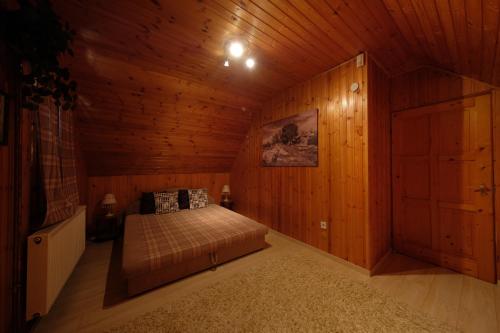 a bedroom with a bed in a wooden cabin at Panoráma Nyaraló in Szentbékkálla