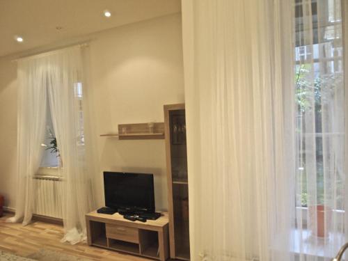 ein Wohnzimmer mit einem TV und einem Fenster in der Unterkunft Charming Apartment Tanja in Zagreb