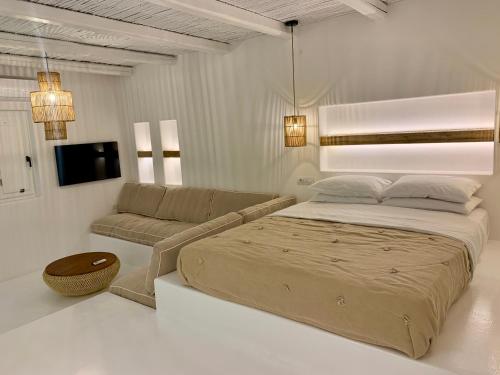 een slaapkamer met een groot bed en een bank bij Yialos Ios Hotel in Ios Chora