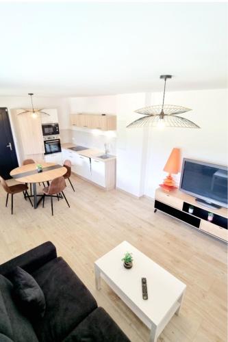 un salon avec un canapé et une table et une cuisine dans l'établissement Au Doubs Moment vue exceptionnelle et panoramique, à Arçon