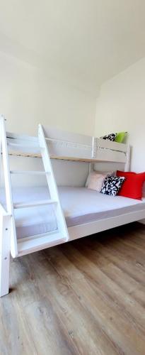 a white bunk bed in a room with a wooden floor at Bobiska Djenovici in Đenovići