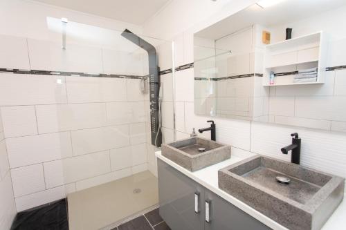 La salle de bains est pourvue de 2 lavabos et de murs carrelés blancs. dans l'établissement BOULEVARD LEGITIMUS, à Pointe-à-Pitre