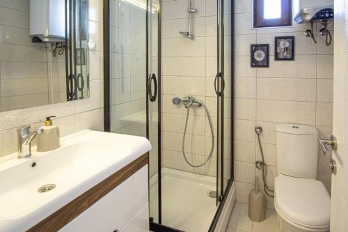 uma casa de banho com um chuveiro, um lavatório e um WC. em Dolphin Residences - Yasemin 1 em Bodrum City