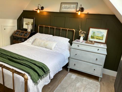 a bedroom with a bed with a green wall at Pear Tree Loft in Lacock