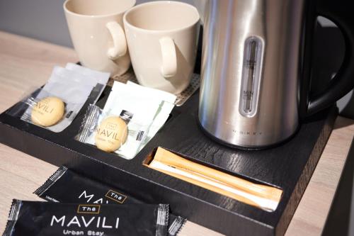 a table with a coffee pot and cups and chopsticks at The Mavili urban stay in Thessaloniki