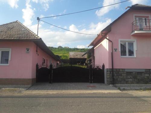 a couple of pink houses with a black gate at Chata Milan in Hrabušice