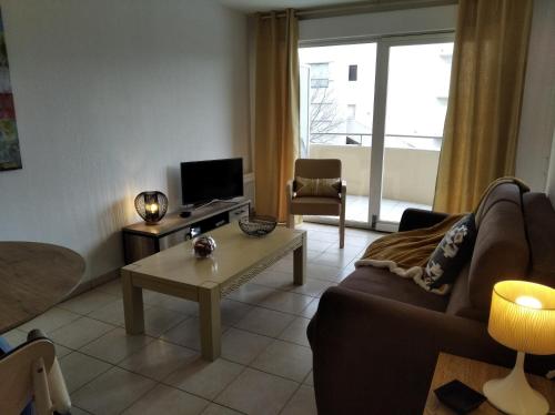 uma sala de estar com um sofá e uma mesa em Sainte Rosalie em Cannes