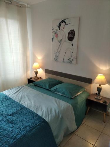 - une chambre avec un lit, deux lampes et une photo dans l'établissement Sainte Rosalie, à Cannes