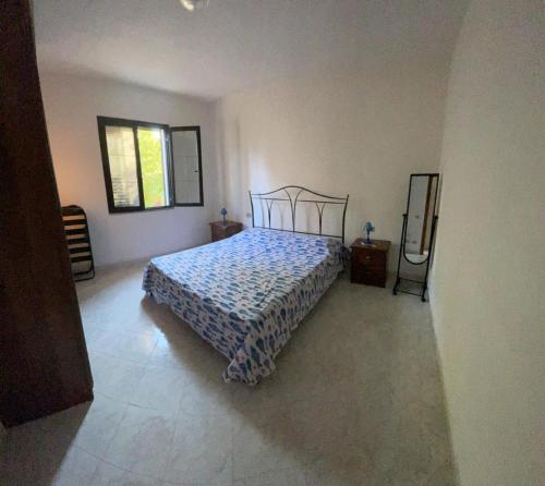 a bedroom with a bed with a blue comforter at Bilo Lu Rattali in San Teodoro