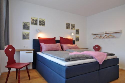 a bedroom with a blue bed and a red chair at Ferienwohnung Zulehenweg 15 in Schönau am Königssee