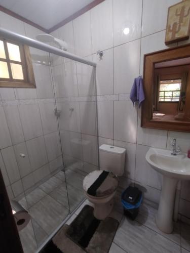 een badkamer met een douche, een toilet en een wastafel bij Chalés de Santana in Tiradentes