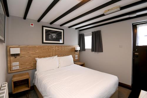 ein Schlafzimmer mit einem großen weißen Bett in einem Zimmer in der Unterkunft Swan, Thatcham by Marston's Inns in Thatcham