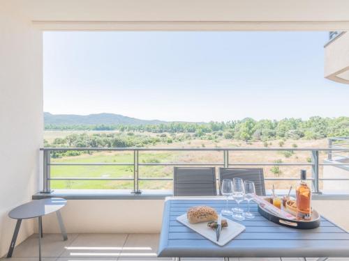 une table bleue avec des verres à vin sur un balcon dans l'établissement Apartment Stanatura-4 by Interhome, à Porto-Vecchio