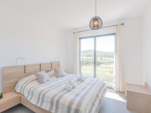 une chambre avec un lit avec une grande fenêtre dans l'établissement Apartment Stanatura-4 by Interhome, à Porto-Vecchio