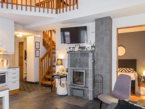 Una sala de estar con chimenea y un televisor encima. en Holiday Home Keskuskuja b4 by Interhome, en Levi