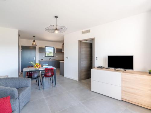 un salon avec une télévision et une table avec des chaises dans l'établissement Apartment Stanatura-5 by Interhome, à Porto-Vecchio