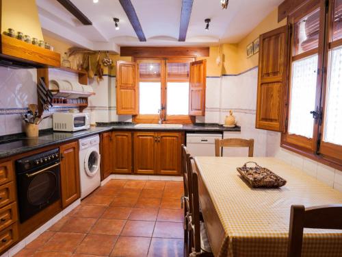 una cocina con armarios de madera y una mesa con mantel. en Holiday Home Rosa by Interhome en Cabanes