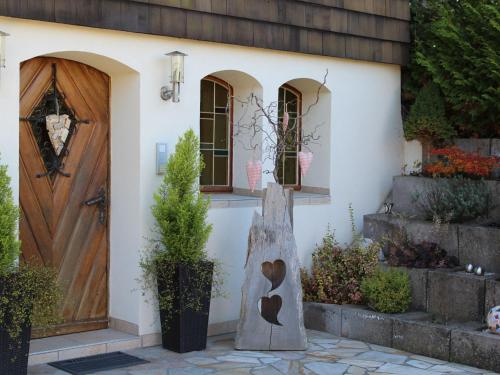 uma porta da frente de uma casa com uma porta de madeira em Apartment Ehinger by Interhome em Eisenbach