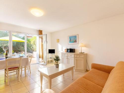 a living room with a couch and a table at Holiday Home Le Mas d'Esquières 16 by Interhome in Les Issambres