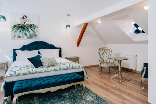 een slaapkamer met een bed en een tafel en stoelen bij Casa Gallo in Sibiu