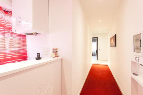 una cucina con armadi bianchi e pavimento rosso di B&B Sol Romae a Roma