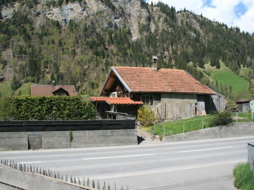a house on the side of a road with a mountain at Apartment Chalet Bifigen by Interhome in Kandergrund