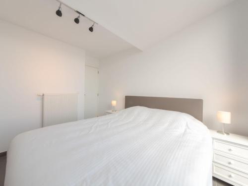 1 dormitorio blanco con 1 cama blanca grande y luces en Apartment Schietbaanstraat by Interhome, en Ostende