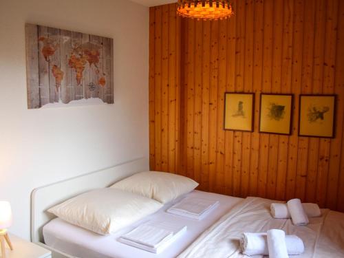 a bed in a room with a wooden wall at Chalet Chalet Les Pitchounes by Interhome in Moleson