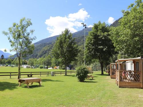 un parco con panchine, recinzione e montagne di Holiday Home Draucamping-2 by Interhome a Sachsenburg