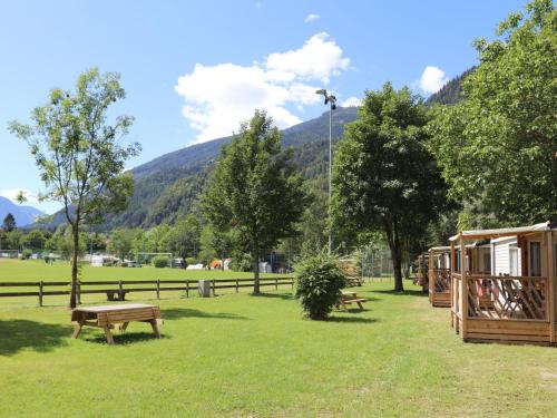 a park with benches and a fence and mountains at Holiday Home Draucamping-2 by Interhome in Sachsenburg