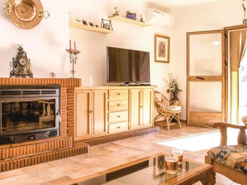 a living room with a television and a fireplace at Holiday Home Las Tijeras by Interhome in Rute