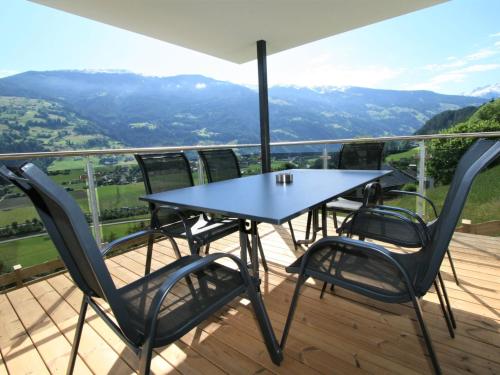 a table and chairs on a balcony with a view at Apartment Apartment Georg by Interhome in Kaltenbach