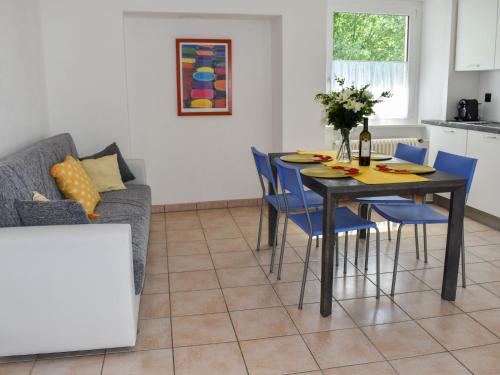 a dining room with a table and blue chairs at Apartment Le Bolle by Interhome in Magadino