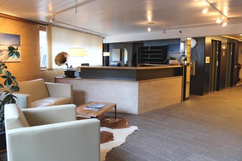 eine Lobby mit Sofas und eine Bar in einem Restaurant in der Unterkunft Eden Resort Anzère in Anzère