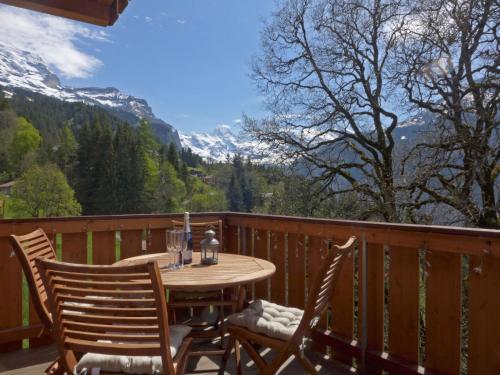 a table and chairs on a balcony with mountains at Apartment Racer's Retreat Apt-2 by Interhome in Wengen