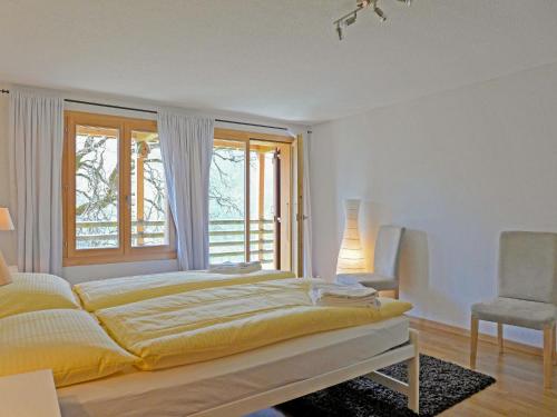 a bedroom with a bed and a window and a chair at Apartment Racer's Retreat Apt-2 by Interhome in Wengen