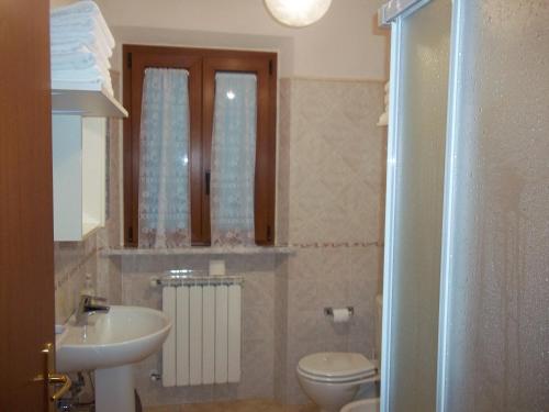 a bathroom with a sink and a toilet and a mirror at Caddelovi in Fibbialla