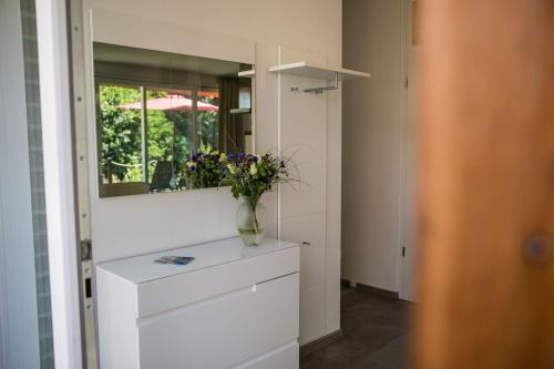 a vase of flowers on a dresser in a room at Residenz - Sonnenglut - Seeterrasse - Sauna - Parkplatz in Bad Zwischenahn