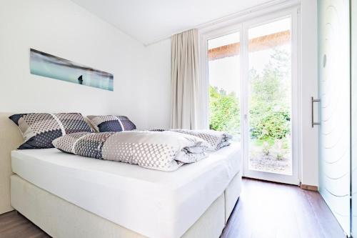 una camera bianca con un letto e una finestra di Residenz - Sonnenglut - Seeterrasse - Sauna - Parkplatz a Bad Zwischenahn