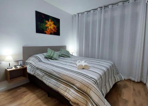 a bedroom with a bed with two towels on it at Apartamento Top, 3 quartos, Wi-Fi 300 Mbps in Porto Alegre