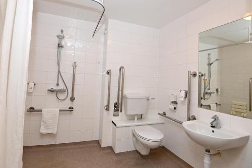 a white bathroom with a toilet and a sink at Meadow Farm Redditch by Marstons Inns in Redditch