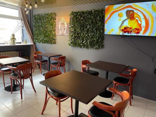 un ristorante con tavoli e sedie e una TV a parete di Chambres d'hôtes et Gîte Felicidade a Mer