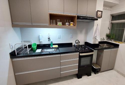 cocina con fregadero y fogones horno superior en Apartamento Top, 3 quartos, Wi-Fi 300 Mbps, en Porto Alegre