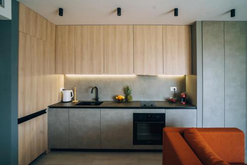 a kitchen with wooden cabinets and a sink and a couch at Solis Apartments Bol in Bol