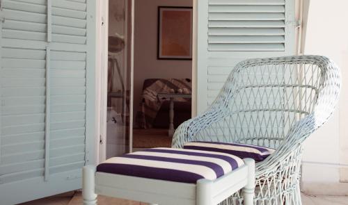 a white wicker chair with a blue and white cushion at Casa di Campara in Neum