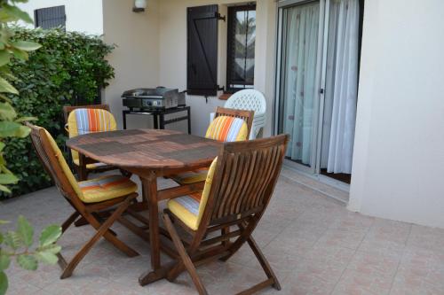 une table et des chaises en bois sur une terrasse dans l'établissement Appartement Saint Cyprien t2 rez de jardin résidence les capitelles, à Saint-Cyprien